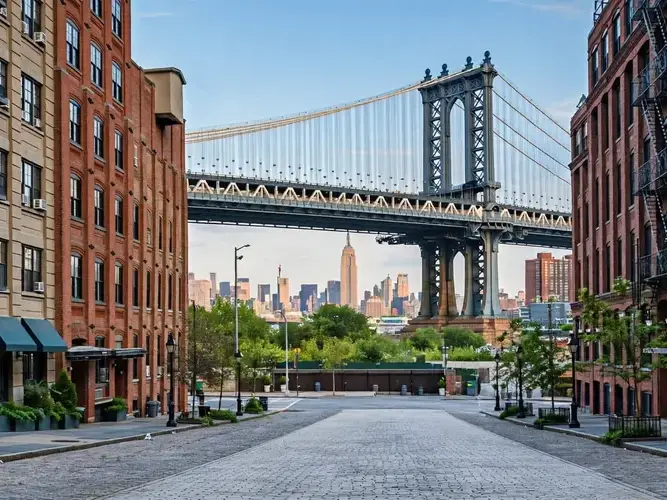 A city street with a large bridge and skyscrapers in the background.